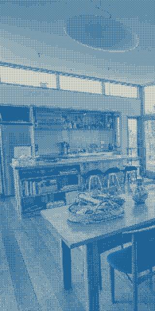 The kitchen can be seen as the dining table stretches before it.